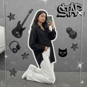 Ultra-realistic 8K cinematic portrait of a young woman kneeling near a mirror, wearing a loose black shirt and white pants, holding a phone for a selfie. Natural hair flow, soft white outline glow, and a modern grayscale collage background featuring an electric guitar, cat face decor, dice, “STAR” graffiti, and glowing 3D stars. Dreamy Instagram-style composition with artistic lighting and mood.