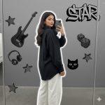 Ultra-detailed 8K cinematic Instagram-style portrait of a stylish young woman standing with her back slightly turned toward a mirror, looking over her shoulder at the camera. She wears a loose black shirt and white pants with minimal jewelry, holding her phone casually. Realistic lighting, soft white outline glow, and grayscale background collage featuring an electric guitar, headphones, dice, cat face decor, metallic stars, and “STAR” graffiti text.